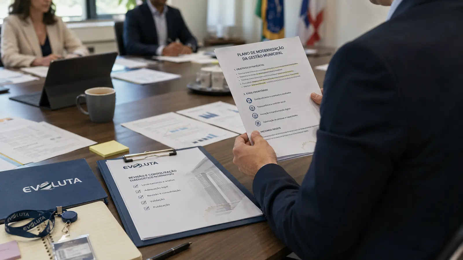 Organograma da prefeitura em revisão sobre a mesa, com pasta da Evoluta e anotações de reestruturação